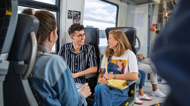 Eine Gruppe jüngerer Leute unterhält sich im Zug