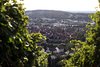 Panoramaansicht einer Stadt mit roten Dächern und grünen Hügeln im Hintergrund.