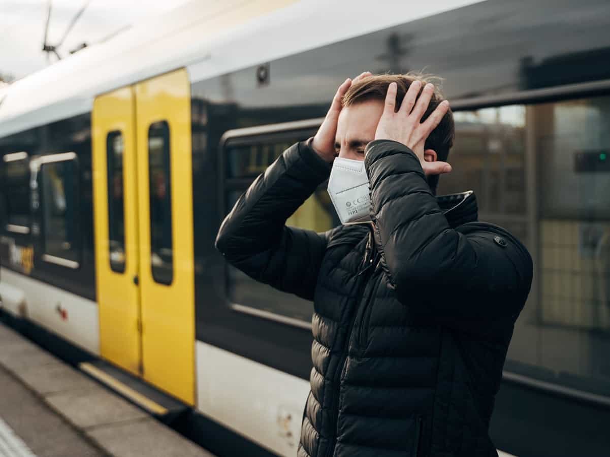 Mann am Bahnsteig schlägt sich die Hände an den Kopf.