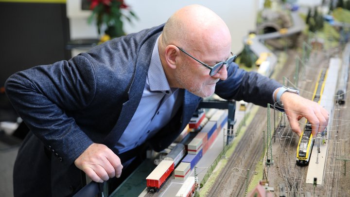 Winfried Hermann steht gebeugt über einer Modelleisenbahn