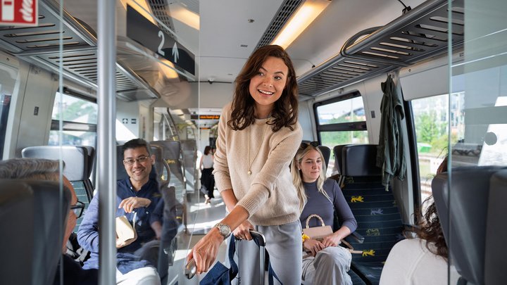 Eine Geschäftsfrau sucht sich mit ihrem Gepäck einen Platz im bwegt-Zug