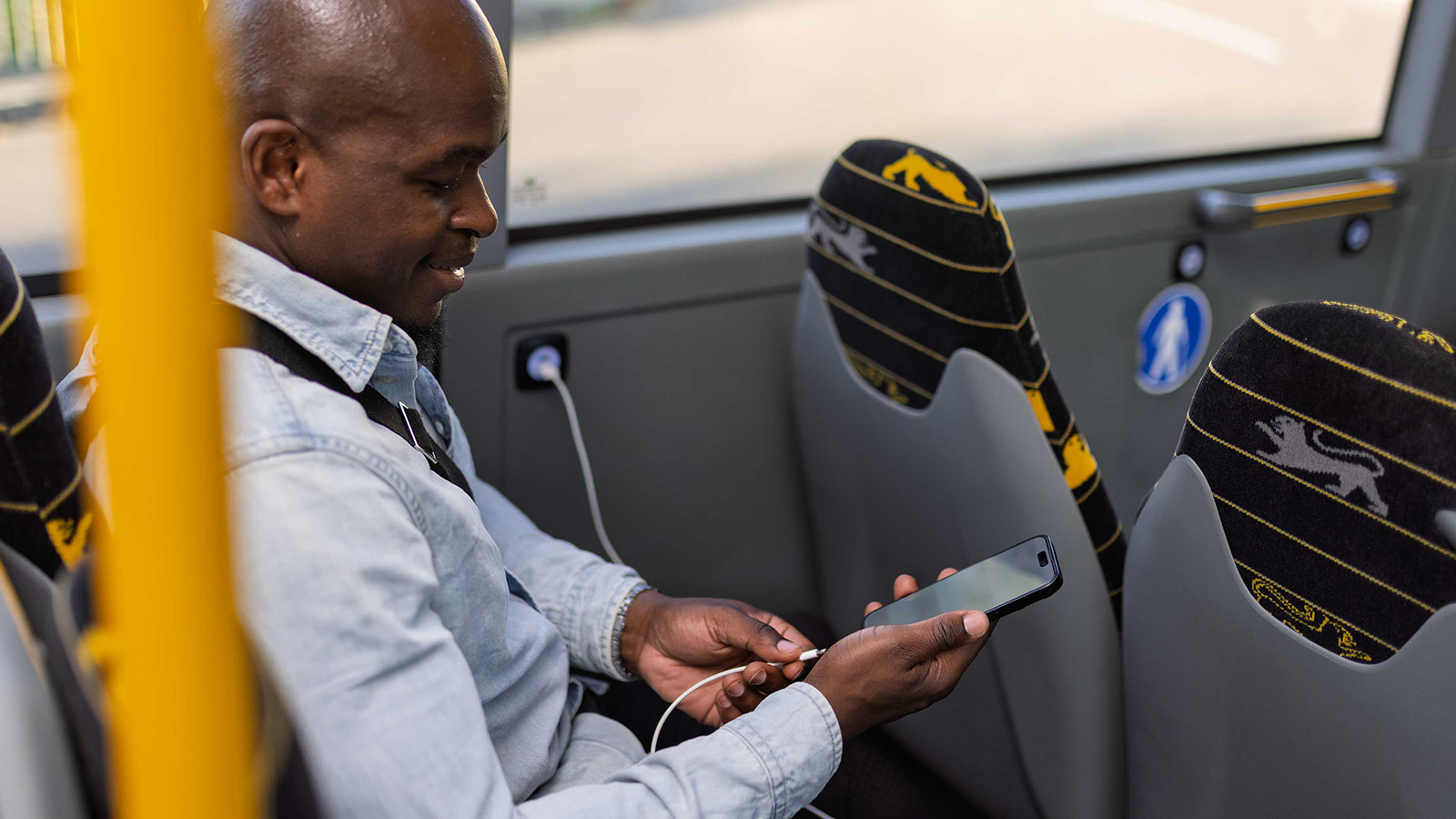 Ein Mann lädt sein Smartphone während der Fahrt in einem bwregiobus