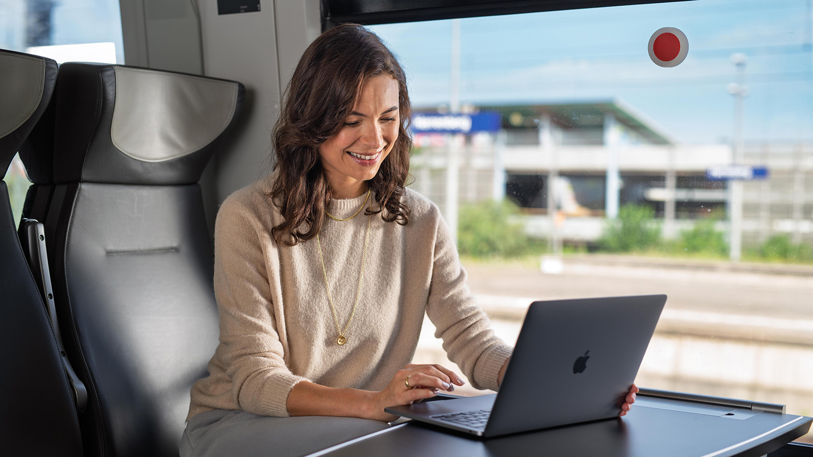 Eine Geschäftsfrau sitzt im bwegt-Zug an ihrem Laptop