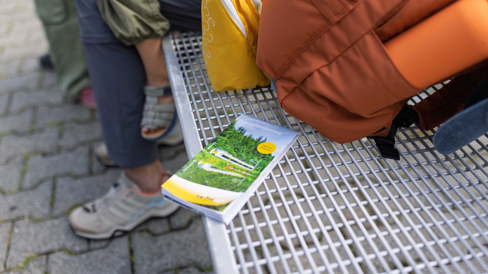 Ein bwegt-Prospekt liegt auf einer Bank an einem Bahnsteig